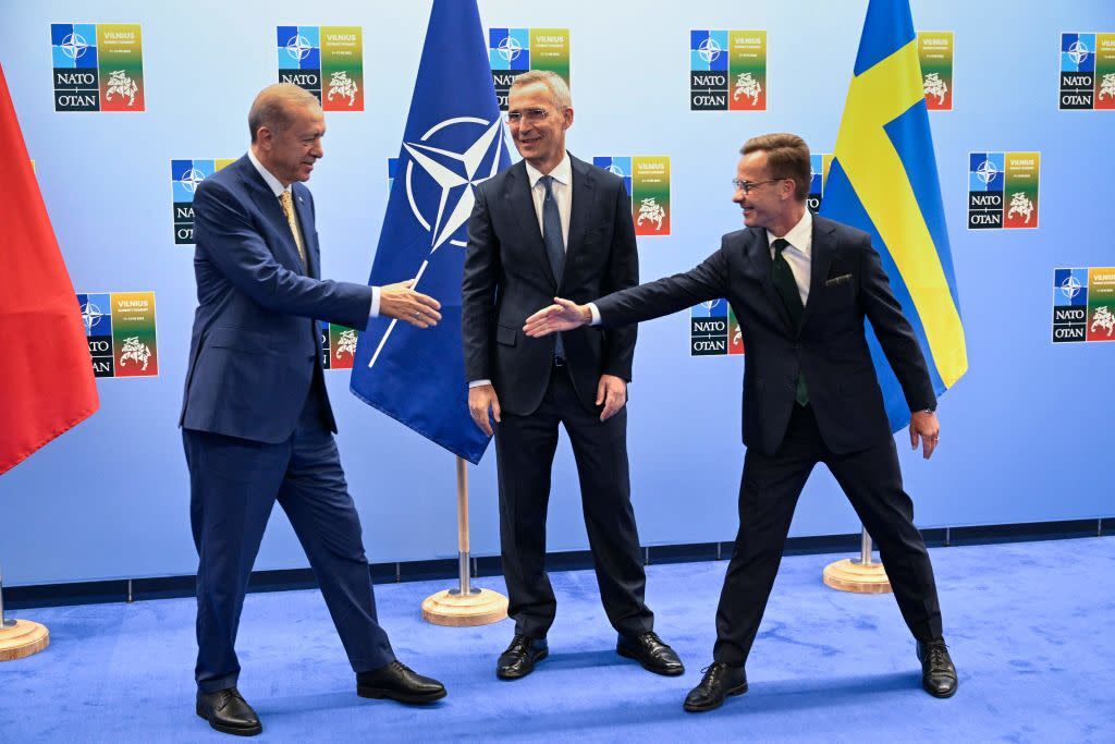 Turkish President Tayyip Erdogan (L) and Swedish Prime Minister Ulf Kristersson shake hands next to NATO Secretary-General Jens Stoltenberg prior to their meeting, on the eve of a NATO summit, in Vilnius.