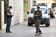 <p>An armed French soldier patrols next to a forensic police officer near the site where a car slammed into soldiers in Levallois-Perret, outside Paris, on August 9, 2017.<br> (Photo: Stephane de Sakutin/AFP/Getty Images) </p>