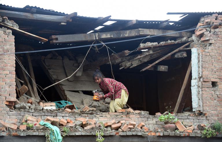 A girl looks for belongings in her damaged house in Bhaktapur on the outskirts of Kathmandu