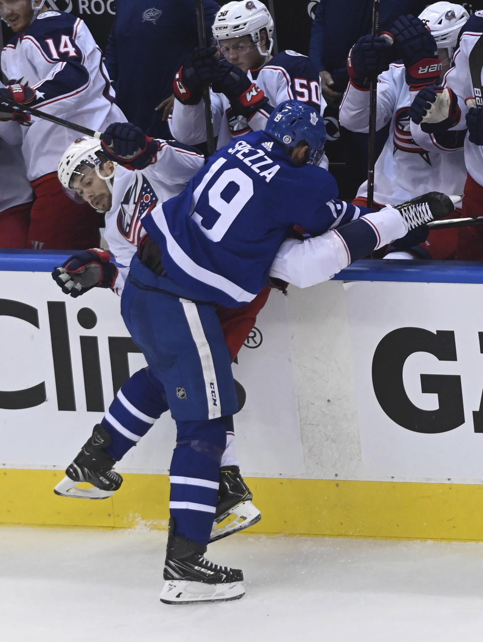 Toronto Maple Leafs center Jason Spezza (19) checks Columbus Blue Jackets right wing Oliver Bjorkstrand (28) into the boards during the second period of an NHL Eastern Conference Stanley Cup playoff game in Toronto on Sunday, Aug. 9, 2020. (Nathan Denette/The Canadian Press via AP)