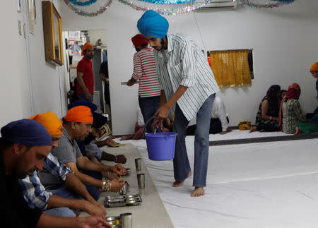 Gursewak Singh serves food to worshippers after prayers given by his father at a Sikh temple in Tokyo, Japan, August 21, 2016. REUTERS/Thomas Wilson