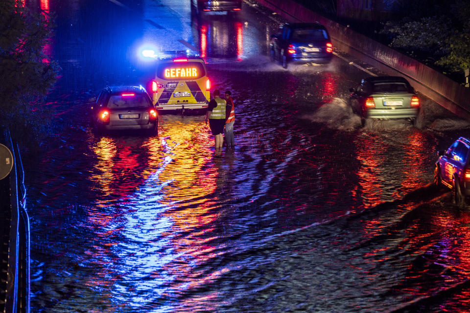 Vehicles drive through a flooded section of the A59 highway as heavy rain falls, Thursday evening, June 22, 2023, in Duisburg, Germany. (Christoph Reichwein/dpa via AP)