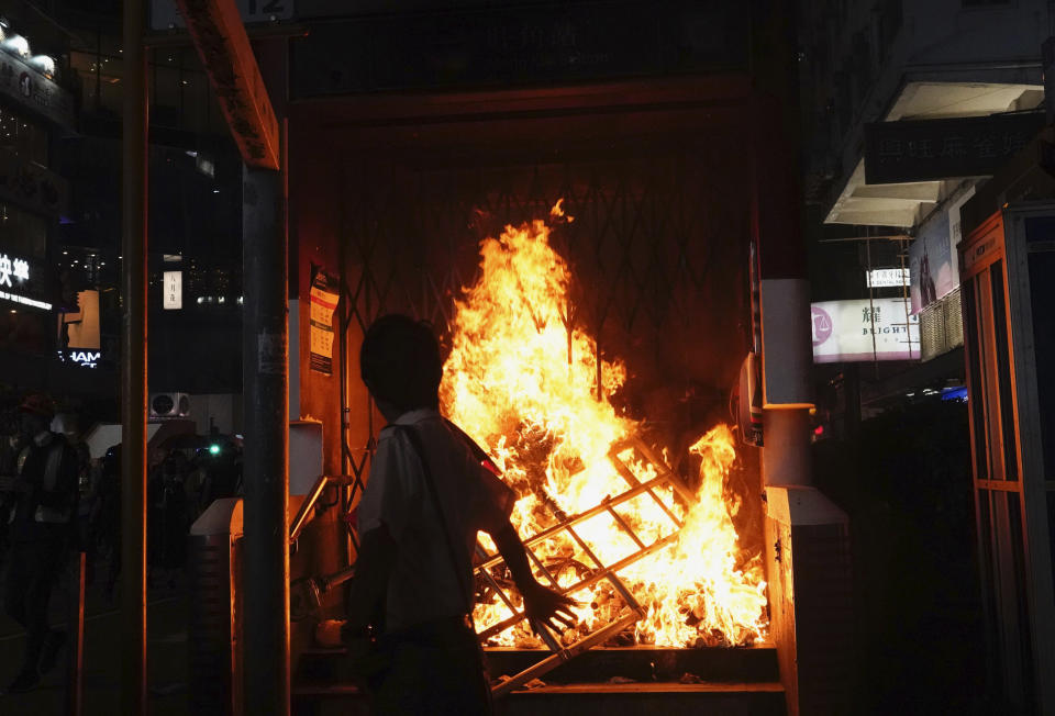 The entrance to a subway station is set on fire during a protest in Hong Kong on Sunday, Oct. 27, 2019. Hong Kong police fired tear gas Sunday to disperse a rally called over concerns about police conduct in monthslong pro-democracy demonstrations, with protesters cursing the officers and calling them "gangster cops." (AP Photo/Vincent Yu)