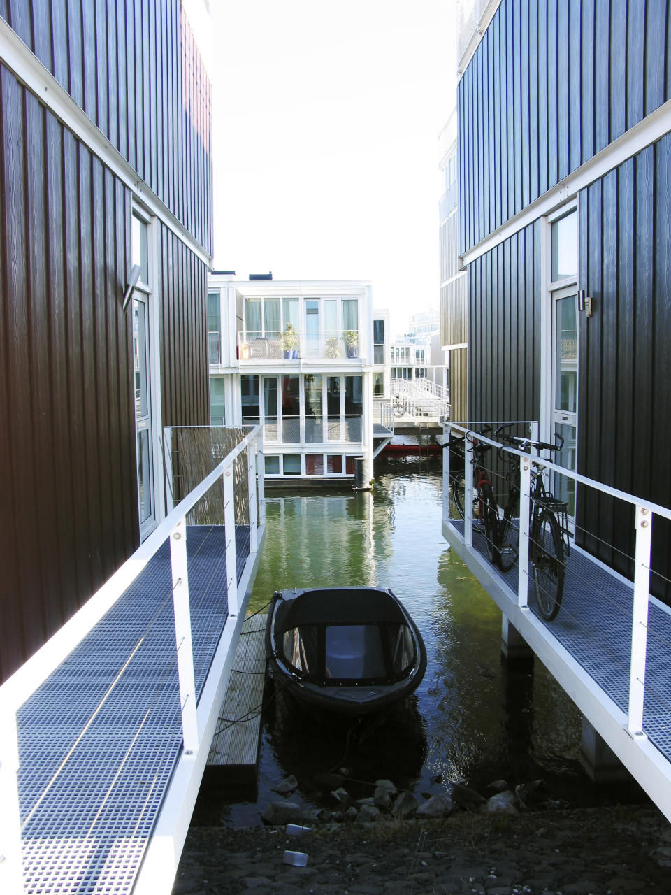 In this photo taken Wednesday, March 28, 2012 a boat floats between amphibious houses in the harbor of the IJburg neighborhood, in Amsterdam. IJburg is a new district in the eastern part of town completely surrounded by water. The Netherlands, a third of which lies below sea level, has been managing water since the Middle Ages and has thus emerged as a pioneer in the field, exporting its expertise to Indonesia, China, Thailand, Dubai and the Republic of the Maldives, an Indian Ocean archipelago that with a maximum elevation of about 2 meters (8 feet) is the world's lowest country. (AP Photo/Margriet Faber)