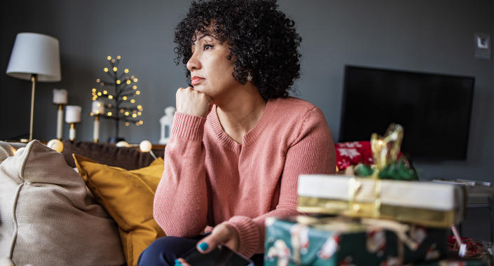 Woman not feeling festive sitting at home at Christmas. (Getty Images)