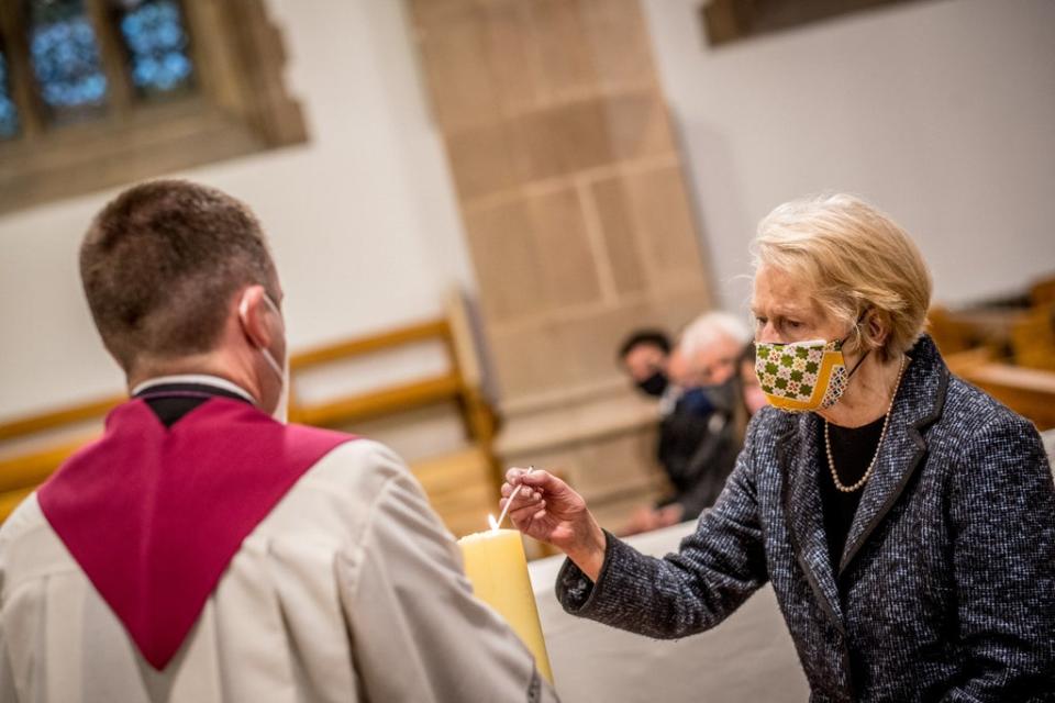 John Hume’s wife, Pat, lights a candle as her husband’s coffin is brought to St Eugene’s Cathedral in Londonderry at his funeral last year (Peter Latimer/PA) (PA Archive)