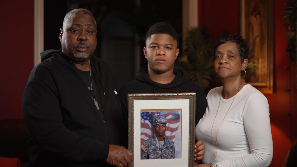 Tony and Patricia Davis pose with a photo of son Anthony Magee, and Magee's son Kameron.