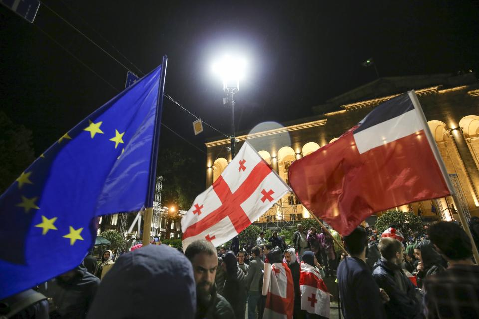 Demonstrators with Georgian national and EU flags gather in front of the Parliament building during a protest rally against "the Russian law" in the center of Tbilisi, Georgia, on Sunday, May 12, 2024. Daily protests are continuing against a proposed bill that critics say would stifle media freedom and obstruct the country's bid to join the European Union. (AP Photo/Zurab Tsertsvadze)