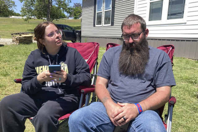 Justin Webster and his wife, Ashleigh, sit outside their Henryetta, Oklahoma, home on Tuesday, May 2, 2023. The couple's daughter, Ivy, 14, was among seven people found slain at a home in Henryetta on Monday. (AP Photo/Sean Murphy)