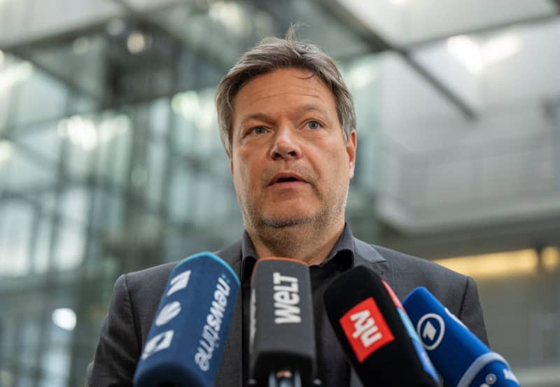 Robert Habeck (L), Germany's Economy Minister speaks to media on his arrival for the Climate Protection and Energy Committees and for the Environment meet for special sessions at the request of the CDU/CSU. Monika Skolimowska/dpa