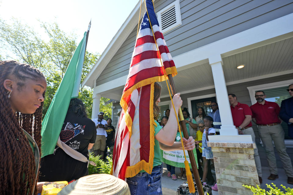 Girls Scouts present flags in front of Opal Lee's new house in Fort Worth, Texas, Friday, June 14, 2024. Habitat for Humanity built Lee the home on the same lot where as a child a white mob destroyed her family's home driving them away. (AP Photo/LM Otero)