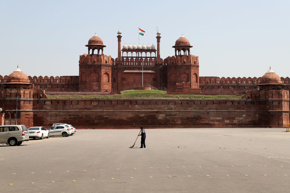 Un trabajador limpia la calle el 21 de marzo delante del Fuerte Rojo de Delhi (India), que permanece cerrado al público. (Foto: Nasir Kachroo / NurPhoto / Getty Images).