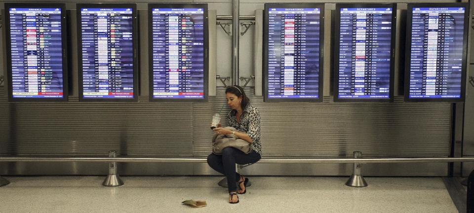 FILE - In this Nov. 22, 2011, file photo, Victoria Puerto checks her flight information and tickets near flight status boards at the Miami International Airport in Miami. Airlines are slowly, steadily recovering from their meltdown five years ago, when, under the strain of near-record consumer travel demand, their performance tanked. Industry performance for all four measurements was slightly better in 2011 compared with 2010, according to the report being released Monday, April 2, 2012. (AP Photo/J Pat Carter, File)