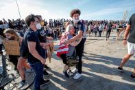 A woman is comforted after a tanker truck drove into thousands of protesters marching on 35W north bound highway during a protest against the death in Minneapolis police custody of George Floyd, in Minneapolis