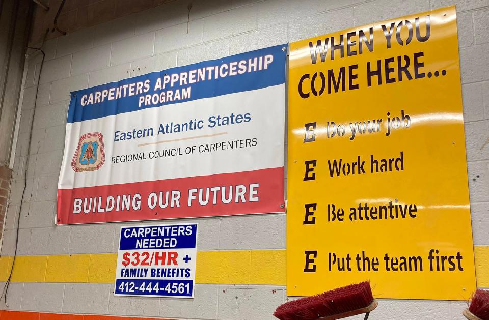A sign in the lab of Erie High construction trades teacher Mike Trippi signals the benefits of a career in carpentry.