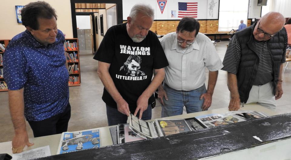 Music historians Scott Hikkinen and Mark Steuer show pictures to Larry Stahl and Steve Foster at the old armory on Otsego Avenue. Stahl and Foster were at the Winter Dance Part concert tour stop in Coshocton that took place just a week after the famous "The Day the Music Died" tragedy.