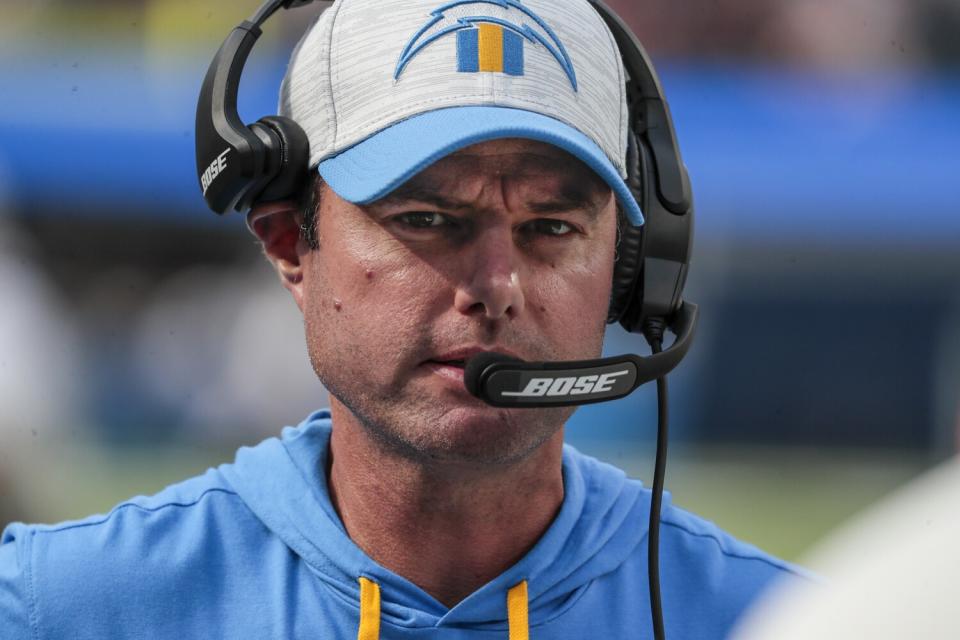 Chargers coach Brandon Staley listens through his headset.