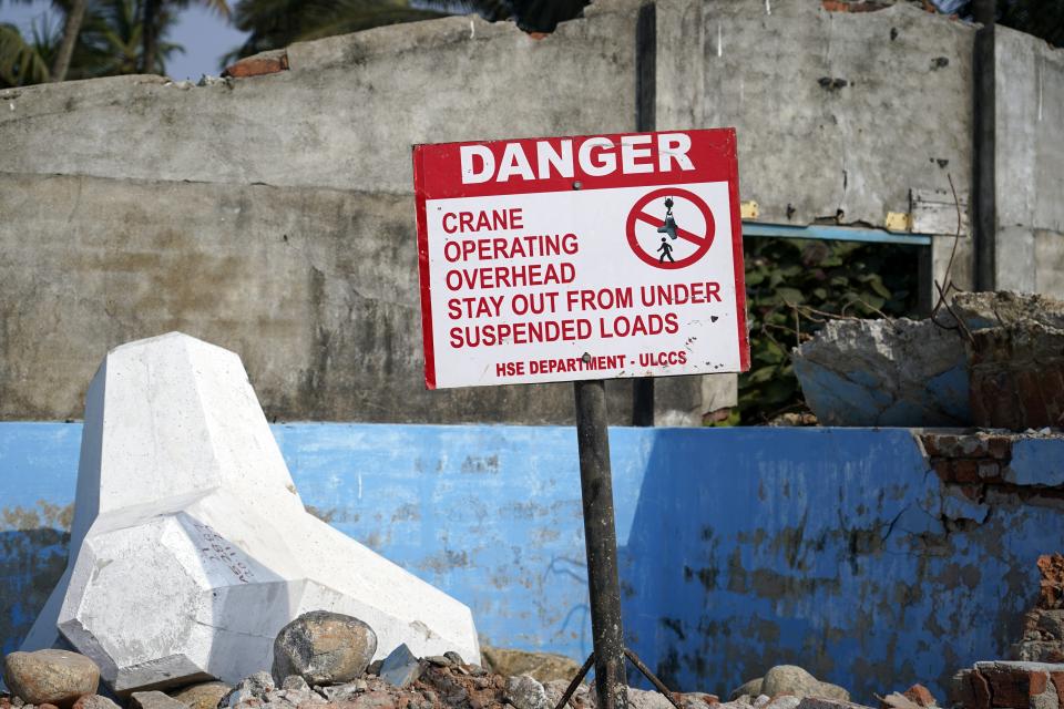 A sign warns of construction of a new sea wall involving tetrapods in Kochi, Kerala state, India, March 4, 2023. Tens of millions of people in India live along coastlines and thus are exposed to major weather events. (AP Photo)