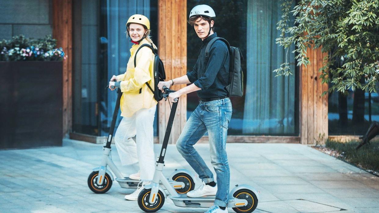 a man and woman on a scooter
