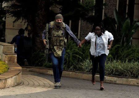 FILE PHOTO: A security agent evacuates an injured woman from the scene where explosions and gunshots were heard at the Dusit hotel compound, in Nairobi, Kenya January 15, 2019. REUTERS/Njeri Mwangi/File Photo