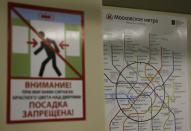 A map of the Moscow metro system is seen behind a poster warning passengers to avoid the closing doors on a metro train in Moscow August 17, 2013 To step onto the Moscow metro is to step back in time and immerse yourself in a museum rich in architecture and history. Opened in 1935, it is an extravagant gallery of Communist design, featuring Soviet artworks, statues, chandeliers, stained glass and ceiling mosaics. Built under Stalin, the metro now transports 7 to 9 million people a day and costs 30 Rubles, around $1, for a single ride. Picture taken August 17, 2013. REUTERS/Phil Noble (RUSSIA - Tags: TRANSPORT SOCIETY) ATTENTION EDITORS: PICTURE 13 OF 24 FOR PACKAGE 'RIDING THE MOSCOW METRO' SEARCH 'MOSCOW CHANDELIERS' FOR ALL IMAGES