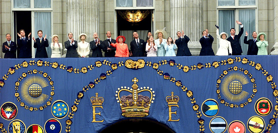 <p>The Queen, centre in red, and other members of the Royal Family watch an RAF flypast over Buckingham Palace at the end of a weekend celebrating 50 years of her on the throne. (Getty)</p> 