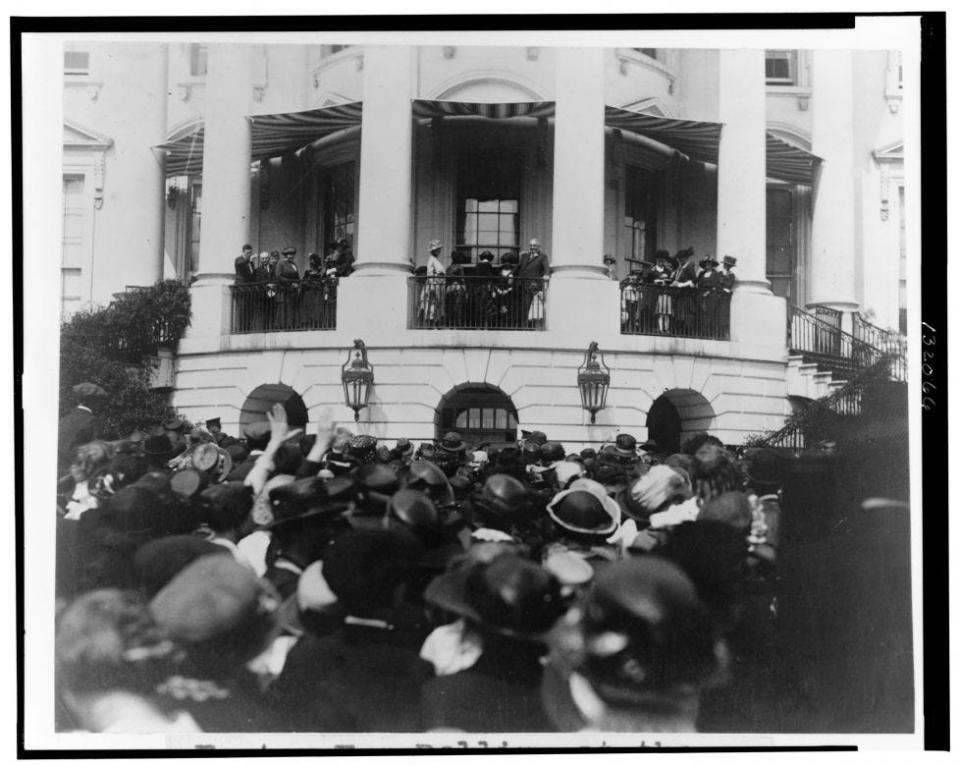 View from the South Lawn of a crowd listening to President Harding speak from the South Portico of the White House before the start of the Easter Egg Roll.