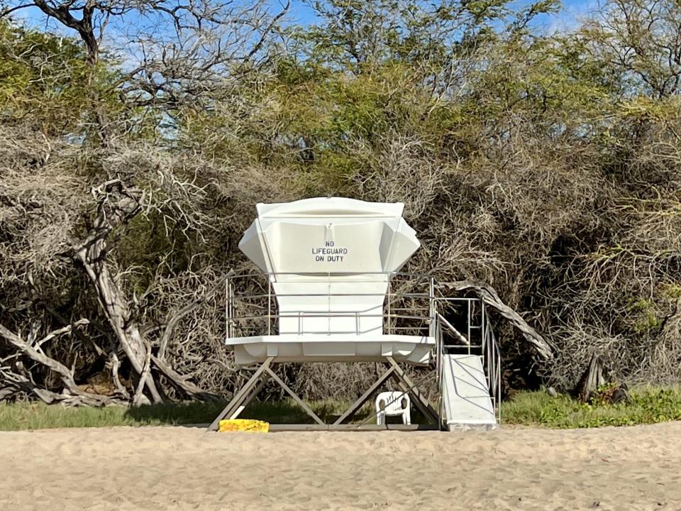 A white lifeguard tower that says "no lifeguard on duty" on Hapuna Beach