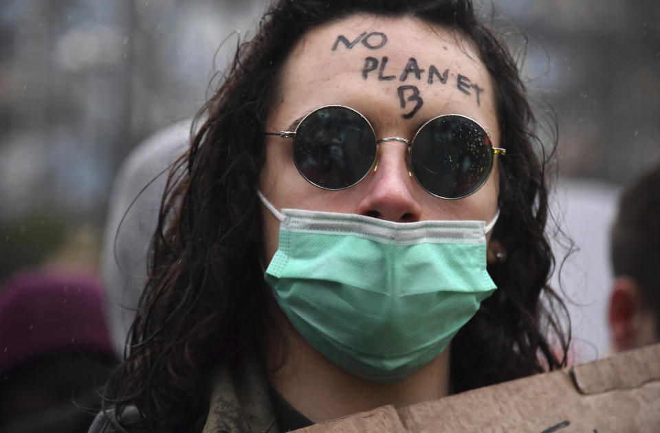 A girl wears a face mask and has a message written on her forehead that reads 'no planet B' during a demonstration against climate change in Brussels, Thursday, Jan. 17, 2019. Thousands of students as part of the Youth for Climate movement took time off school Thursday to call for stronger action against climate change. (AP Photo/Geert Vanden Wijngaert)