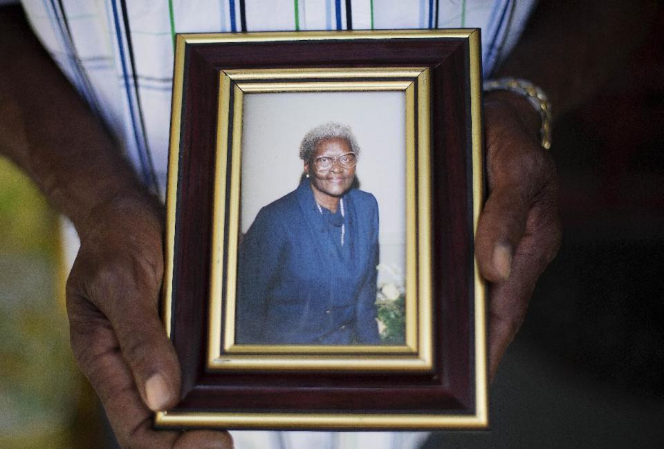 FILE -In this Friday, June 19, 2015 file photo, Walter Jackson holds a photo of his mother Susie Jackson, one of the nine people killed in Wednesday's shooting at Emanuel AME Church by Dylan Roof, as he stands on his front porch, in Charleston, S.C. During Dylan Roof's sentencing for friends and family members walked up to the witness stand and testified about the nine black church members gunned down during a Bible study. The testimony came during the sentencing phase of Dylann Roof's death penalty trial. (AP Photo/David Goldman, File)