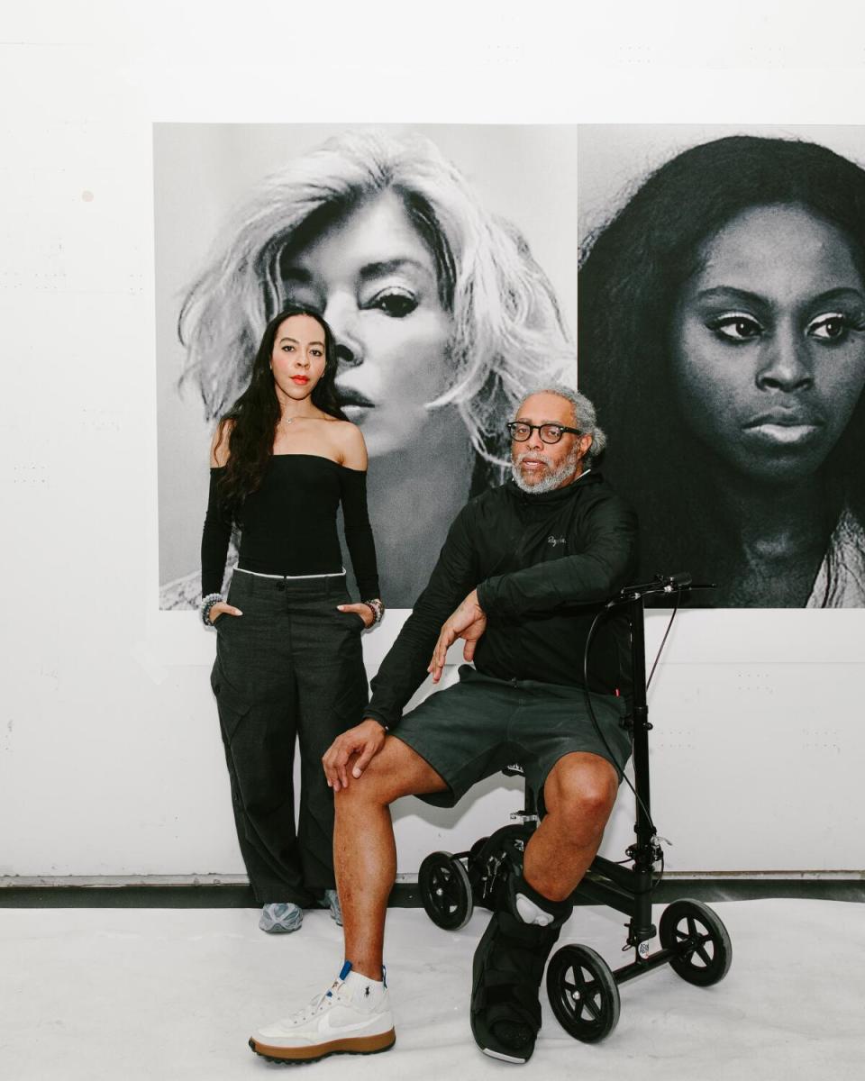 Harmony Holiday and Arthur Jafa pose in front of one of his paintings.