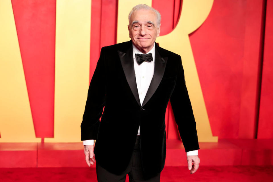Man in a black tuxedo standing on a red carpet