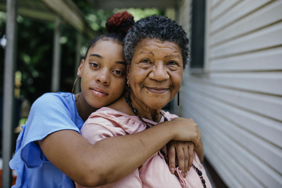 Portrait of black grandmother with teenager granddaughter both are looking into the camera. Members of a black middle class America family.