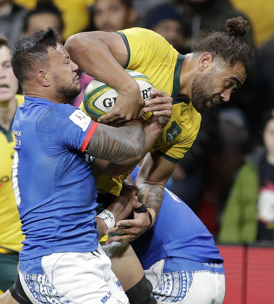 Samoa's Alapati Leiua, left, is unable to hold back Australia's Lukhan Salakaia-Loto as he breaks through to score a try during their rugby union test match in Sydney, Saturday, Sept. 7, 2019. (AP Photo/Rick Rycroft)