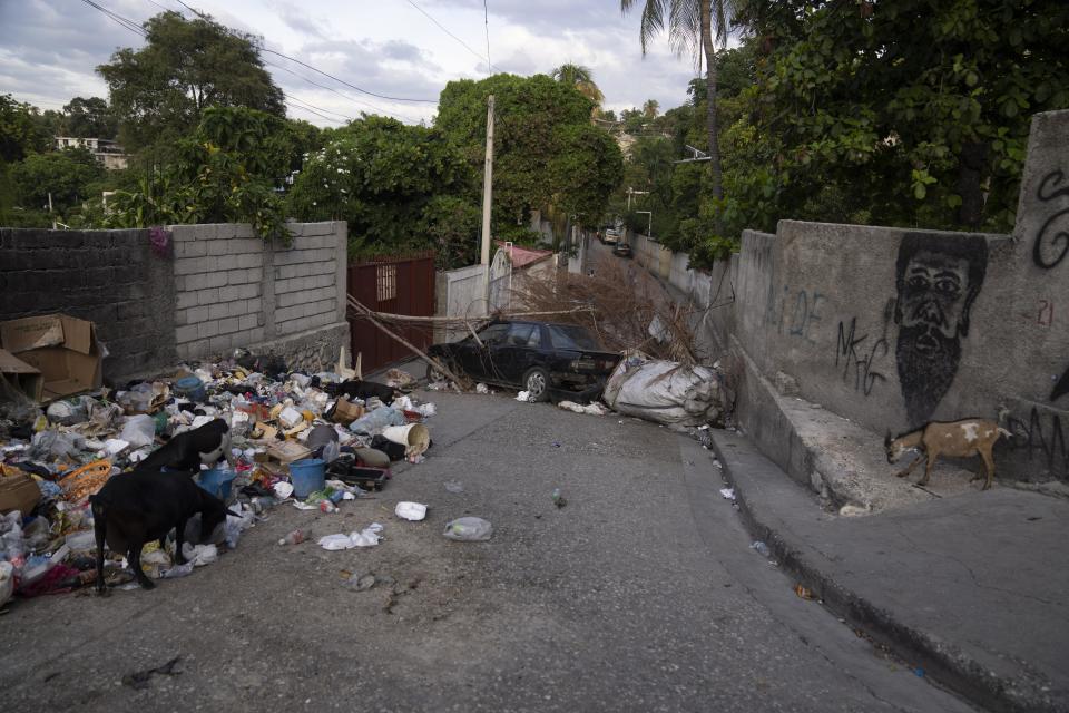 A derelict car blocks a street as part of a barricade erected during the Bwa Kale movement , an initiative to fight gangs seeking to take control of their neighborhood, in Port-au-Prince, Haiti, Wednesday, May 31, 2023. (AP Photo/Ariana Cubillos)