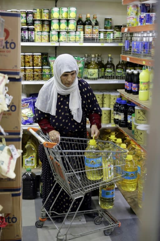 A Syrian refugee shops on June 14, 2017 at a Beirut store accepting cards provided by the World Food Programme and topped up each month with $27 (24 euros) per person