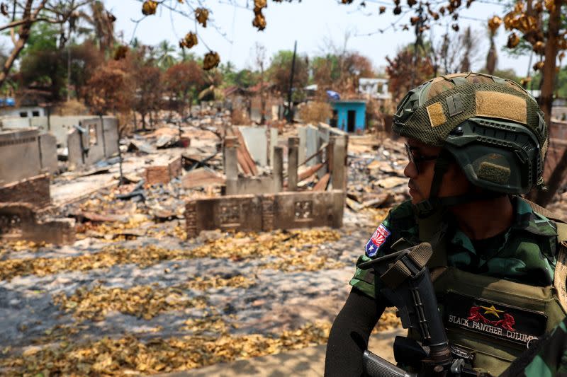 A soldier from the Karen National Liberation Army (KNLA) patrols, next to an area destroyed by Myanmar's airstrike in Myawaddy, the Thailand-Myanmar border town under the control of a coalition of rebel forces led by the Karen National Union