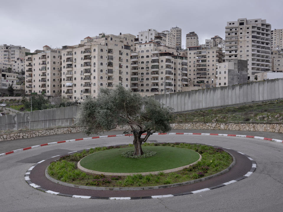 FILE - A section of Israel's separation barrier cuts between the Shuafat refugee camp, in the back, and the east Jerusalem neighborhood of Pisgat Zeev, March 12, 2022. (AP Photo/Oded Balilty, File)