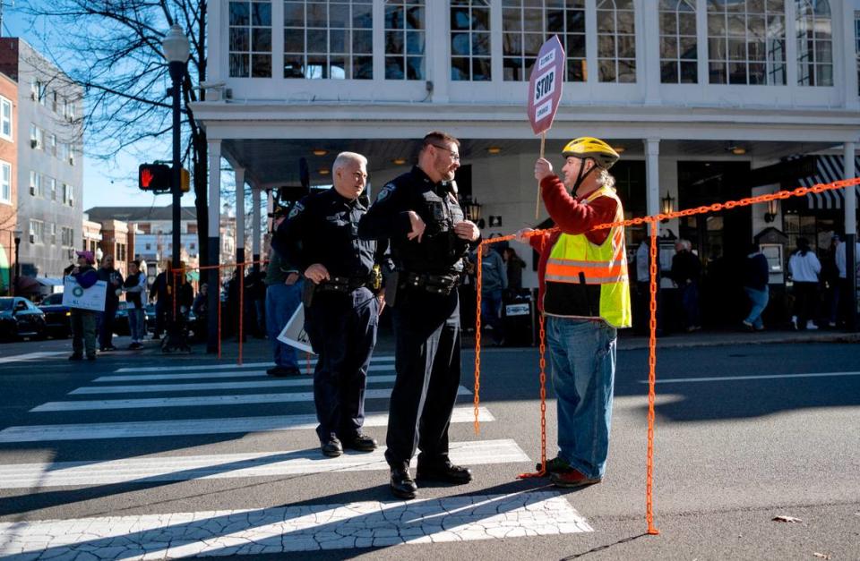 State College police talk to David Thomas Roberts as he blocks traffic on College Avenue at Allen Street on Saturday, Nov. 26, 2022.