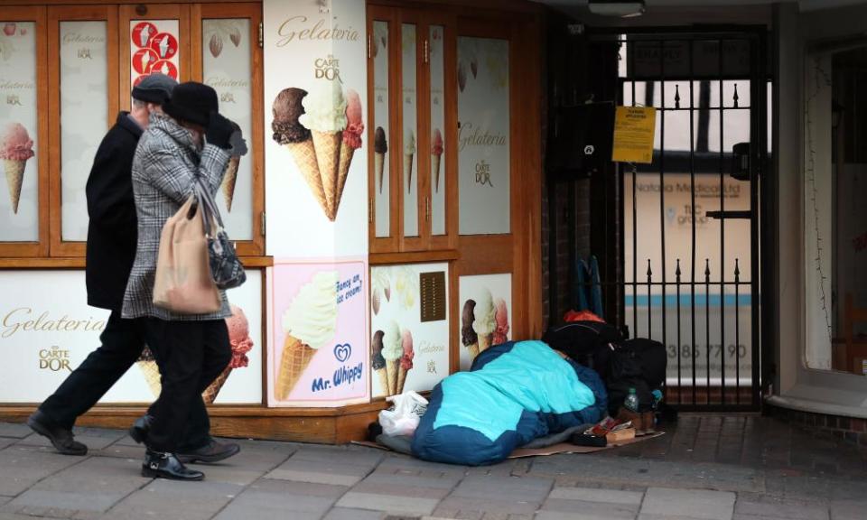 A homeless person sleeps on a street near Windsor Castle.