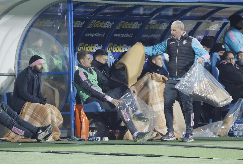 Palermo players receive blankets to shelter from the cold prior to the start of a Serie A soocer match between Empoli and Palermo, at the Carlo Castellani stadium in Empoli, Italy, Saturday, Jan. 7, 2017. Strong winds, snowfalls and unusually low temperatures have been hitting Italy for the last two days. (Fabio Muzzi/ANSA via AP)