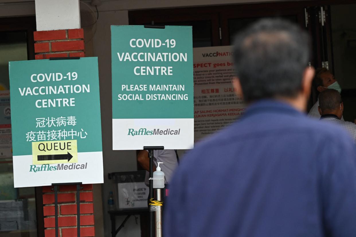 A man looks at signs outside a Covid-19 coronavirus vaccination centre set up at a community centre in Singapore on October 7, 2021. (Photo by Roslan Rahman / AFP) (Photo by ROSLAN RAHMAN/AFP via Getty Images)