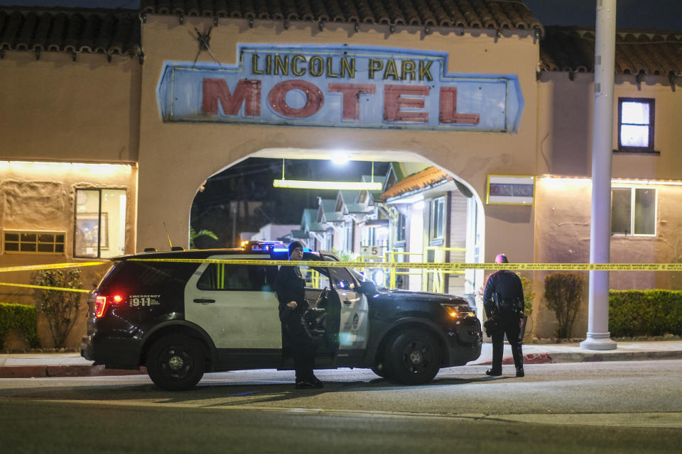 Police officers stand guard near a crime scene where three Los Angeles police officers were shot, Wednesday, March 8, 2023, in Los Angeles. Police said the officers were hospitalized and in stable condition. (AP Photo/Ringo H.W. Chiu)