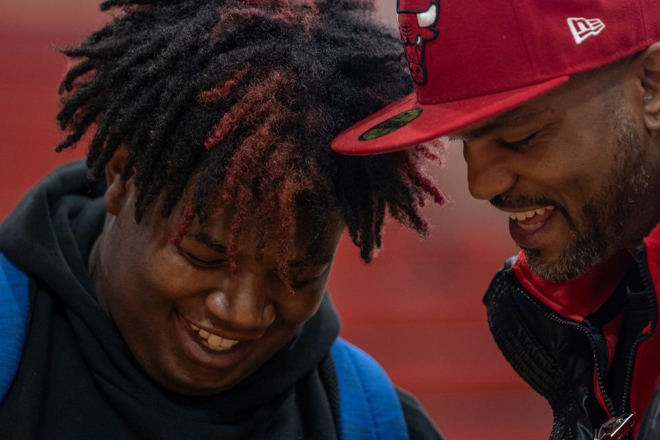 Osborn High School student Jaiden Mabins, left, shows his 4.0 grade point average to Deonte Morris, right, of Detroit, a member of the 4s, while talking after rival gang members from the 4s and 5s unite to preach peace and an end to violence in the aftermath of the killing of 11-year-old Latrelle Mines in early January during an assembly at Osborn High School on Friday, Feb. 2, 2023.