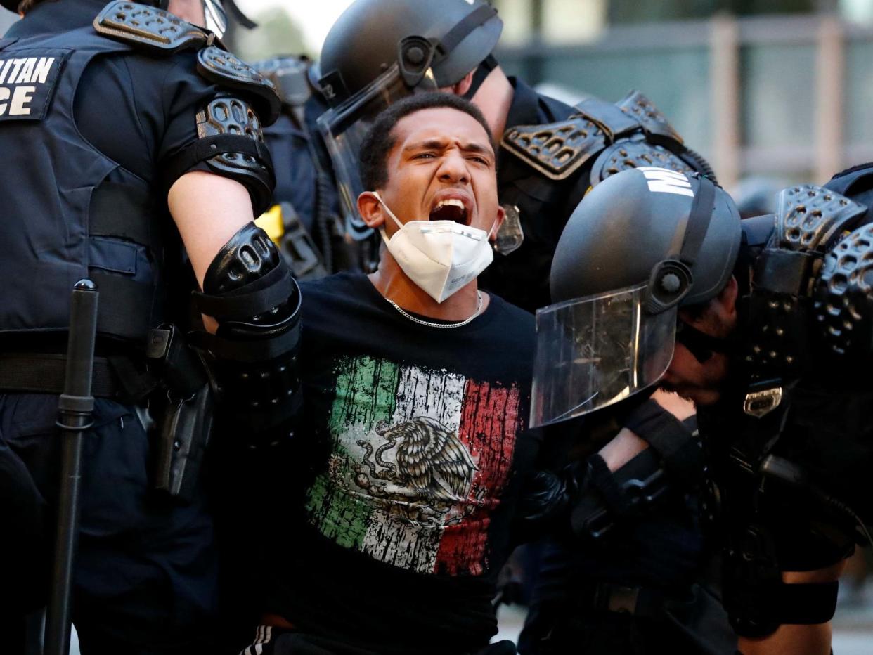 A demonstrator is taken into custody by police after a curfew took effect during a protest over the death of George Floyd, Monday, June 1, 2020, near the White House in Washington. (AP Photo/Alex Brandon): AP