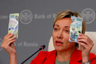 FILE PHOTO: Russian central bank deputy chairwoman Olga Skorobogatova holds the newly designed 100-rouble banknotes dedicated to the 2018 FIFA World Cup, during a news conference in Moscow, Russia May 22, 2018. REUTERS/Sergei Karpukhin/File Photo