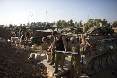 Israeli soldiers prepare armoured personnel carriers (APCs) at a staging area outside the northern Gaza Strip July 27, 2014. REUTERS/Ronen Zvulun