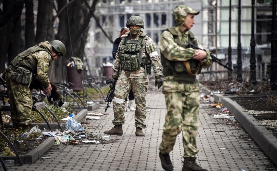 Russian soldiers walks along a street in Mariupol on April 12, 2022, as Russian troops intensify a campaign to take the strategic port city, part of an anticipated massive onslaught across eastern Ukraine, while Russia's President makes a defiant case for the war on Russia's neighbour.  / AFP / Alexander NEMENOV
