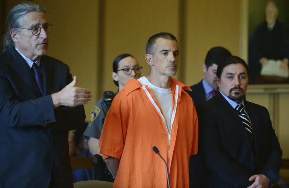 Fotis Dulos, center, listens, as his attorney Norm Pattis, left, addresses the court during a hearing at Stamford Superior Court, Tuesday, June 11, 2019 in Stamford, Conn. Fotis Dulos, and his girlfriend, Michelle Troconis, have been charged with evidence tampering and hindering prosecution in the disappearance of his wife Jennifer Dulos. The mother of five has has been missing since May 24. (Erik Trautmann/Hearst Connecticut Media via AP, Pool)
