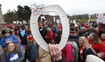 <p>A protester holds a toilet seat as thousands of Kentucky school teachers march Monday morning, April 3, 2018, from the Kentucky Education Association headquarters on Capital Avenue to the State Capitol in Frankfort to protest legislative changes to their pensions and education cuts. (Photo: Charles Bertram/Lexington Herald-Leader via AP) </p>